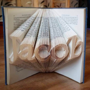 Art piece showing the name "Jacob" cut into the open pages of a book